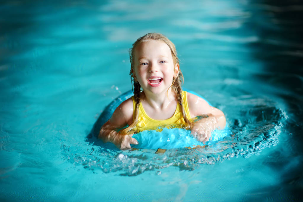 μικρό κορίτσι κολύμβησης με φουσκωτό δαχτυλίδι  - Φωτογραφία, εικόνα