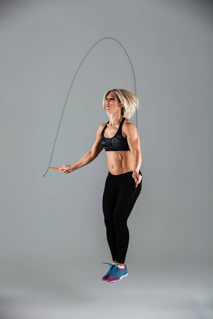 Ολόσωμο πορτρέτο του μυϊκή ενηλίκων αθλήτρια άλμα - Φωτογραφία, εικόνα