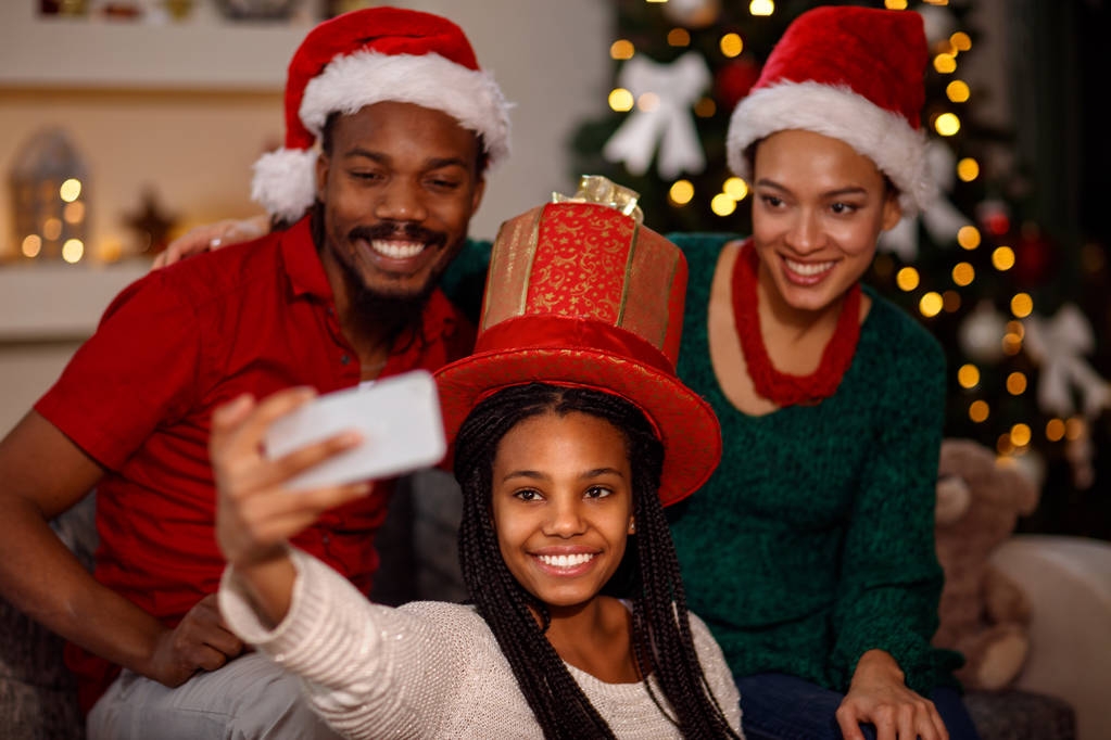 dziewczynka z jej rodziców biorąc selfie na Boże Narodzenie - Zdjęcie, obraz