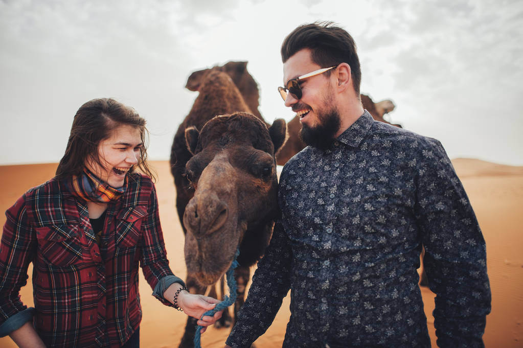 Pareja de viajeros con camello
 - Foto, Imagen