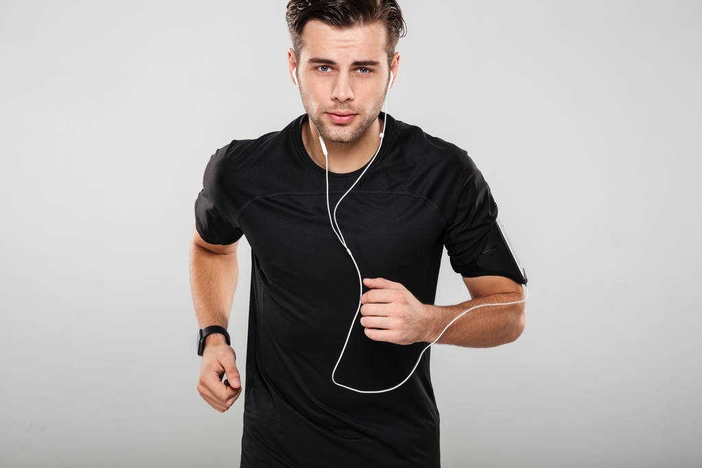 Πορτρέτο ενός αθλητή κίνητρα νεαρό άνδρα στα ακουστικά - Φωτογραφία, εικόνα