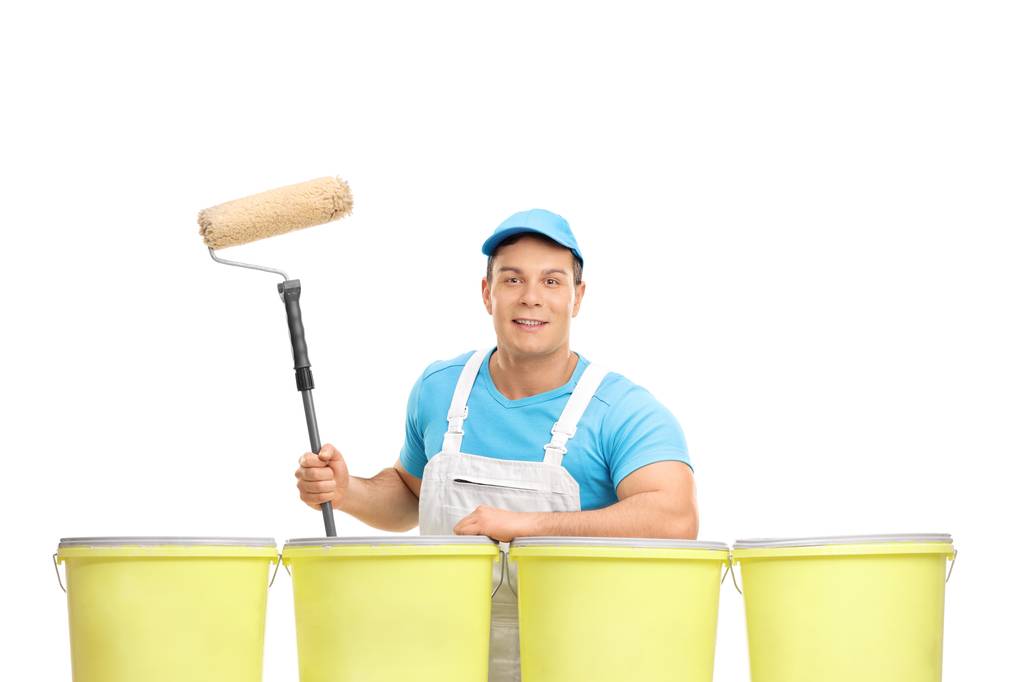 Painter with a paint roller leaning on color buckets - Photo, Image