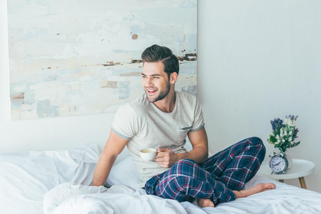 Człowiek pije kawę na łóżku - Zdjęcie, obraz