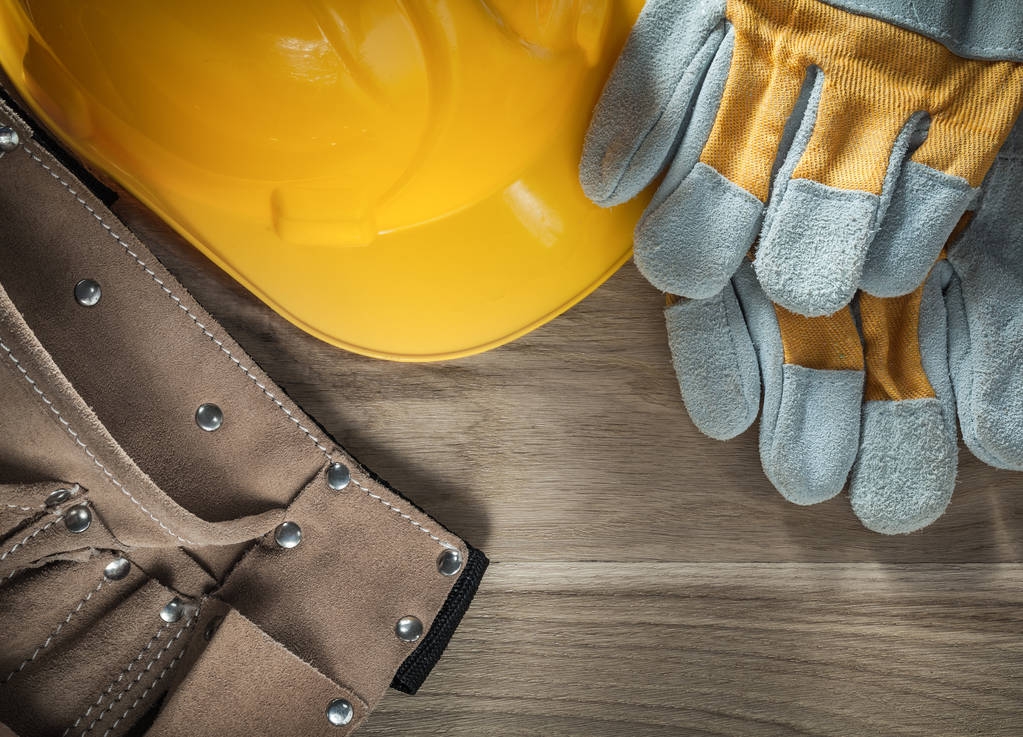 Cuero herramienta cinturón guantes de seguridad sombrero duro en tablero de madera
 - Foto, Imagen