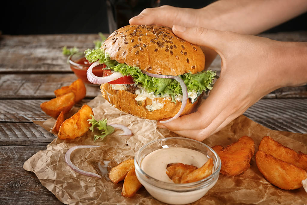 Frau hält leckeren Rindfleisch-Burger  - Foto, Bild