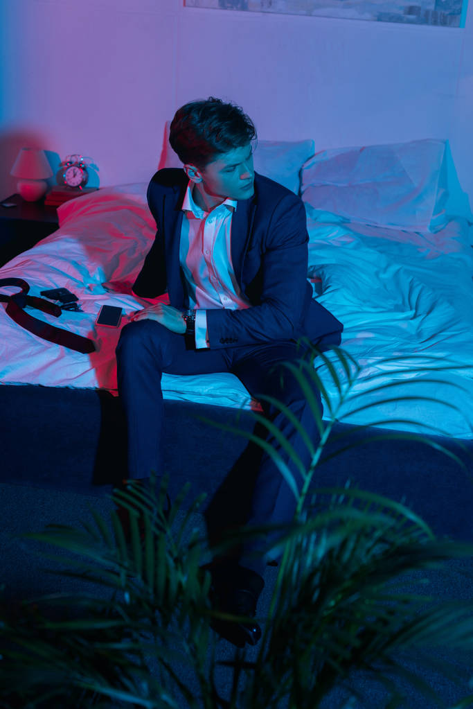 businessman sitting on bed in dark room - Photo, Image