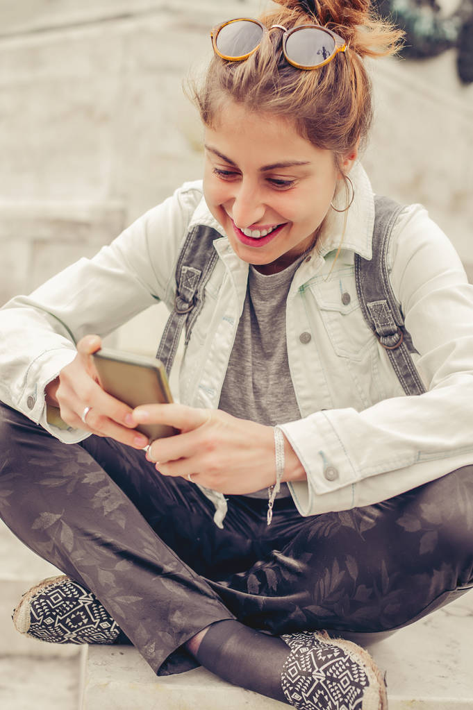 Szczęśliwa kobieta siedzi na ulicy, pisanie wiadomości, rozmowy na inteligentnych - Zdjęcie, obraz