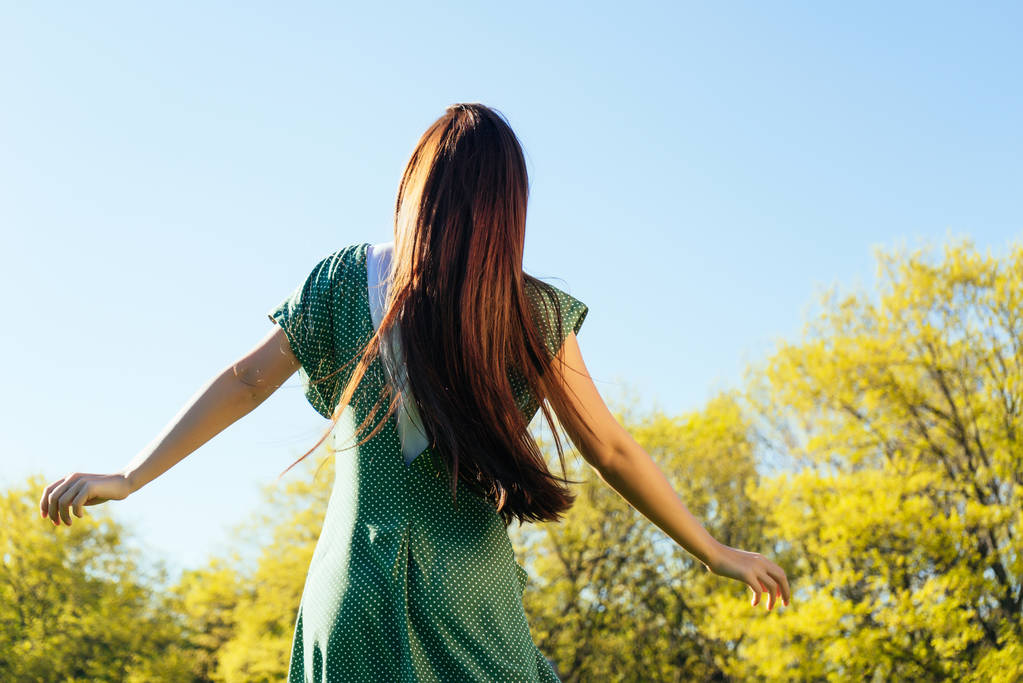 chica de pelo largo camina en el parque, disfruta del sol y el buen tiempo
 - Foto, imagen
