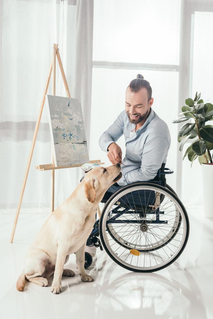 disabled man painting and petting dog - Photo, Image