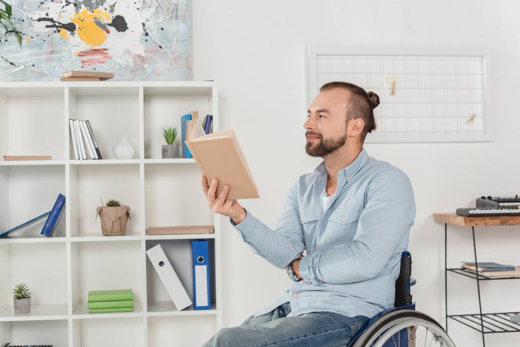 Człowiek na wózku inwalidzkim czytanie książki - Zdjęcie, obraz