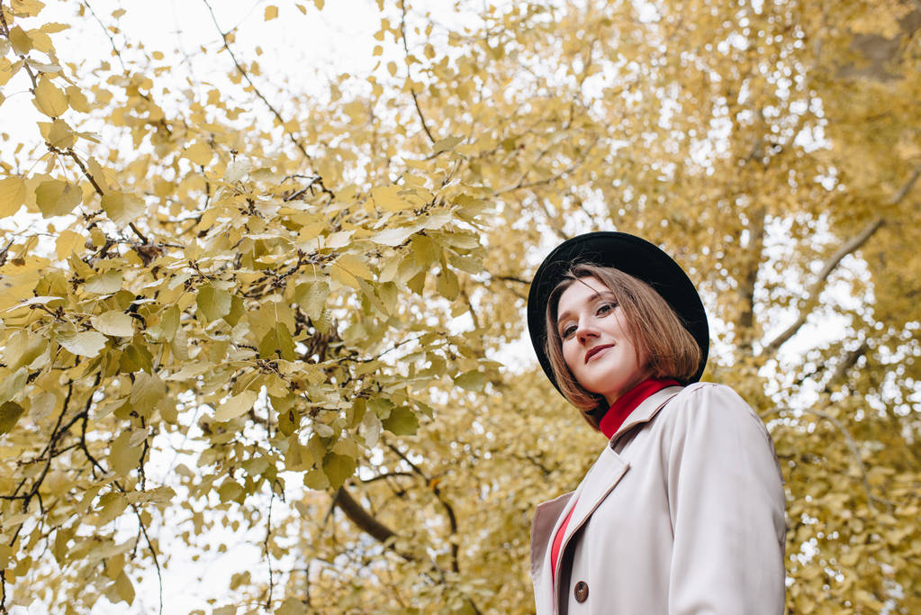 жінка в траншеї пальто і капелюх в парку
 - Фото, зображення