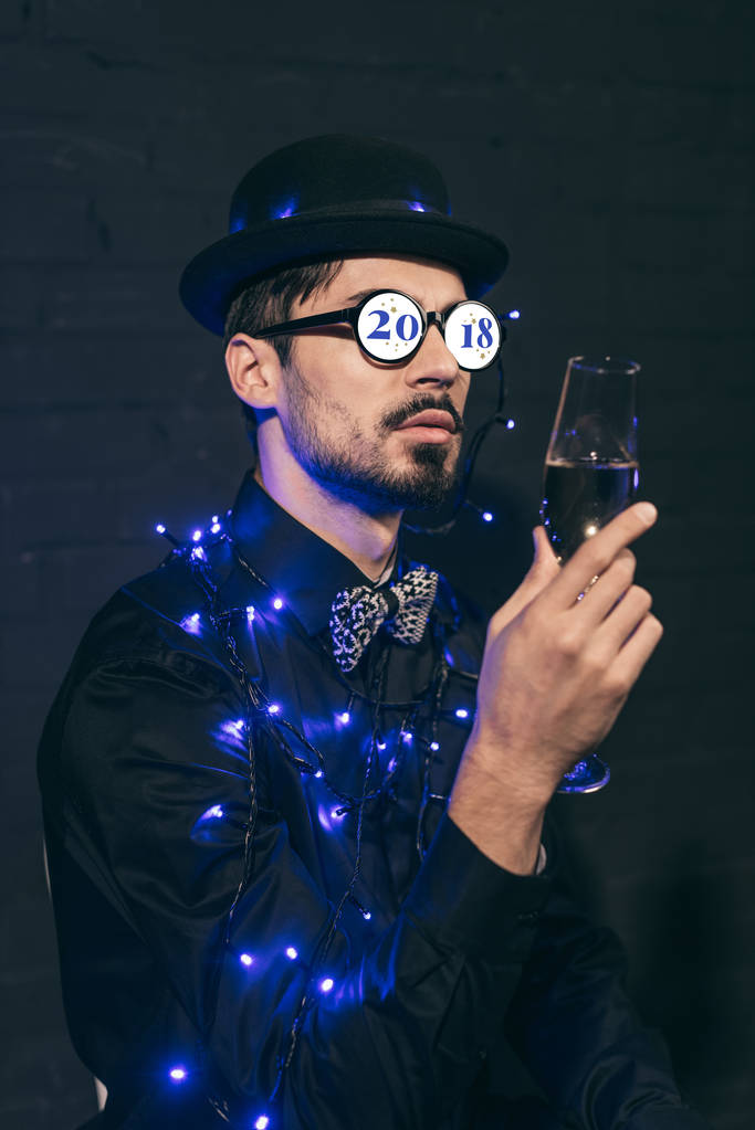 man met champagne en kerst verlichting - Foto, afbeelding
