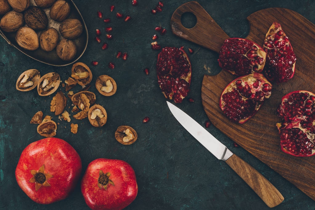 knife and pomegranate on wooden board - Photo, Image