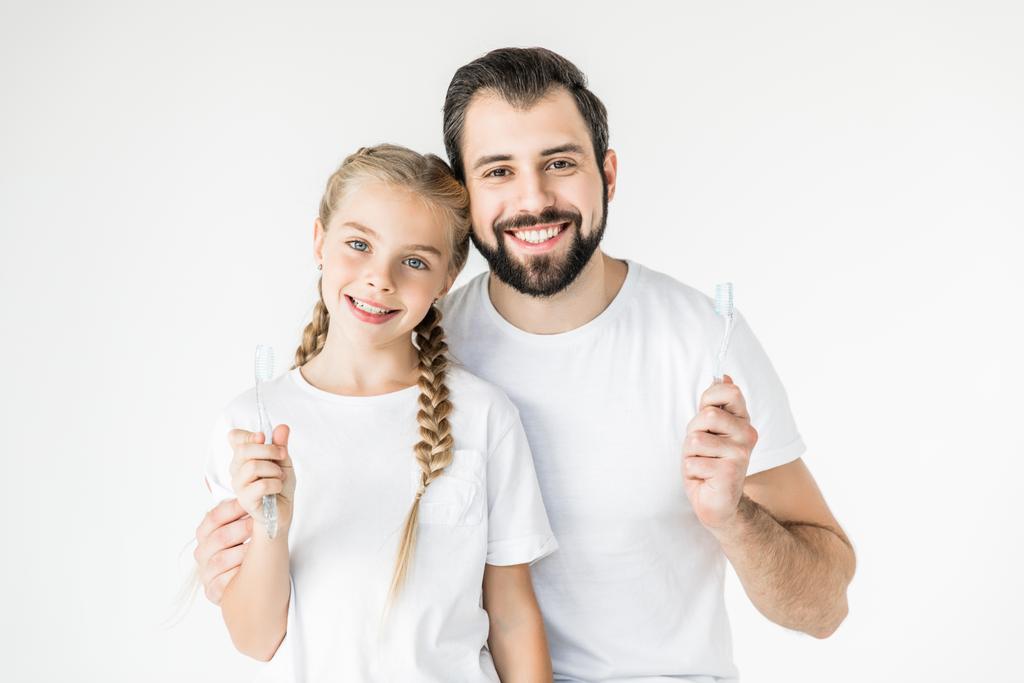 vader en dochter met tandenborstels - Foto, afbeelding
