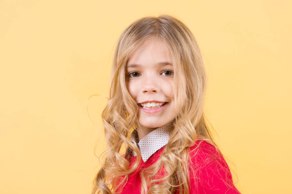 Gyermek göndör szőke haj narancs háttér - Fotó, kép