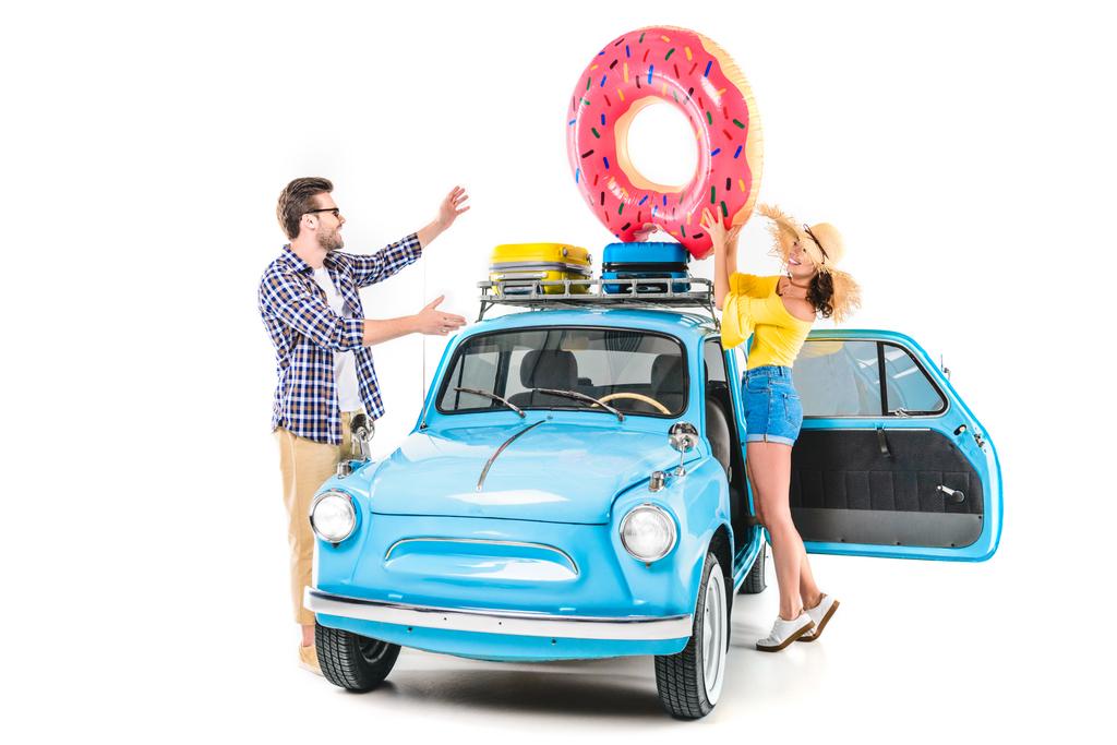 casal colocando donut inflável no carro
 - Foto, Imagem