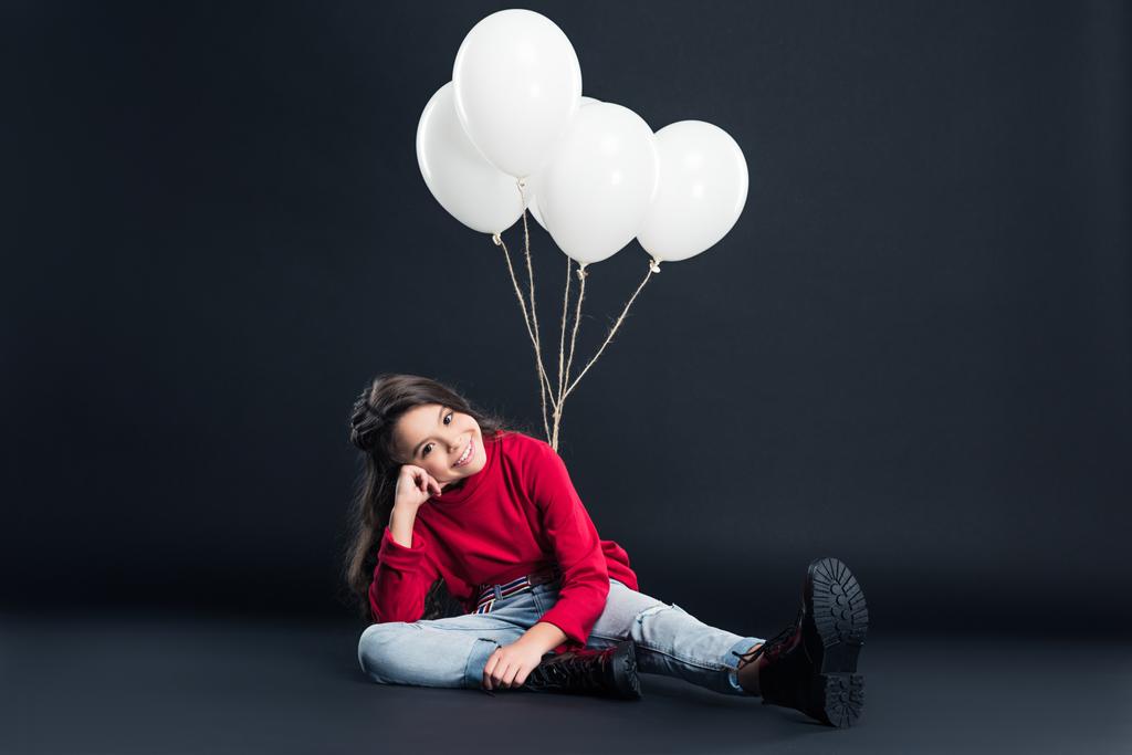 niño sentado atado con paquete de globos
 - Foto, Imagen