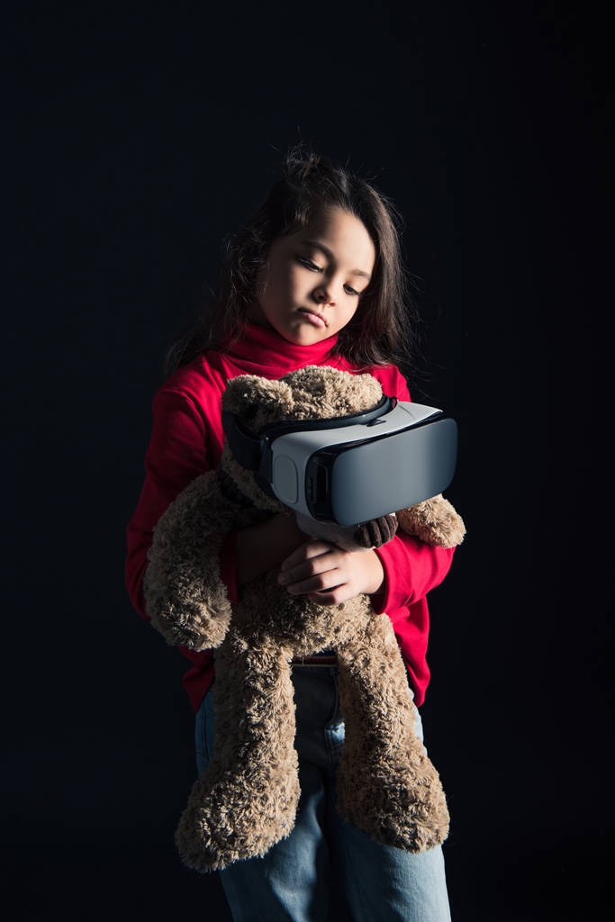 Дитина кладе гарнітуру VR на плюшевого ведмедя
 - Фото, зображення