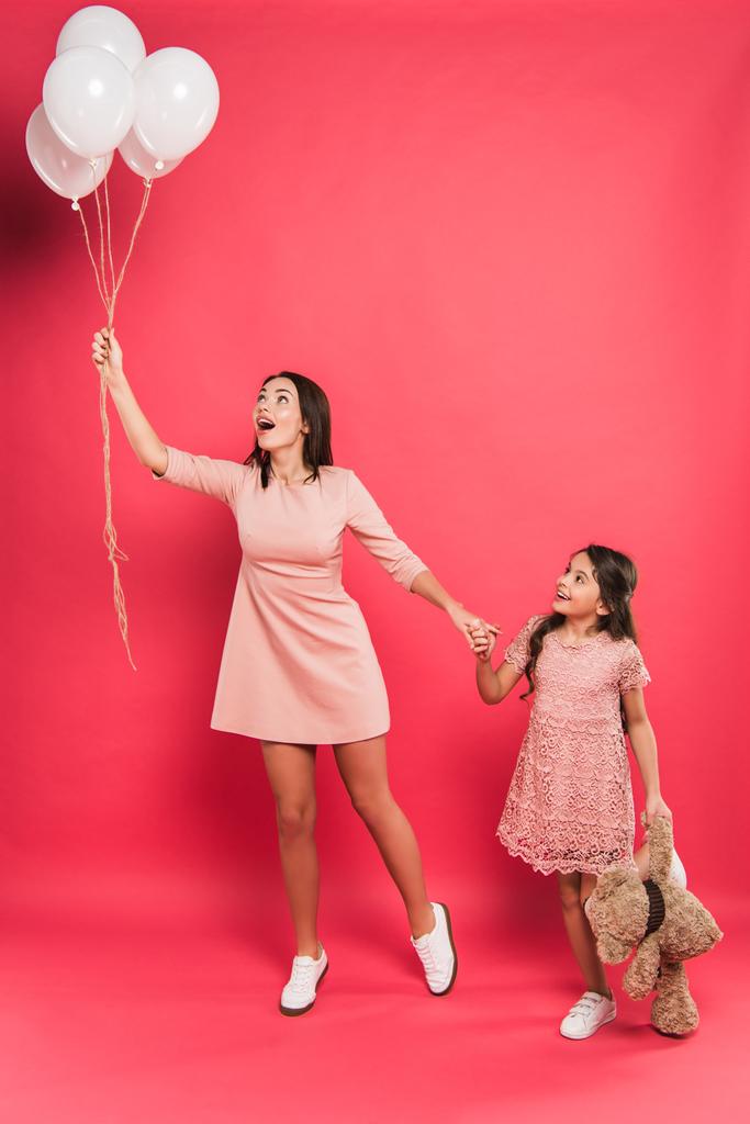 madre e hija mirando globos de helio
 - Foto, Imagen