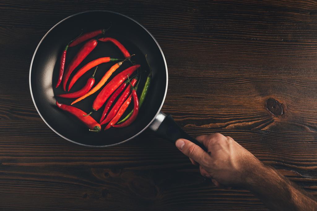 ember tartja a serpenyőben, chili paprika - Fotó, kép