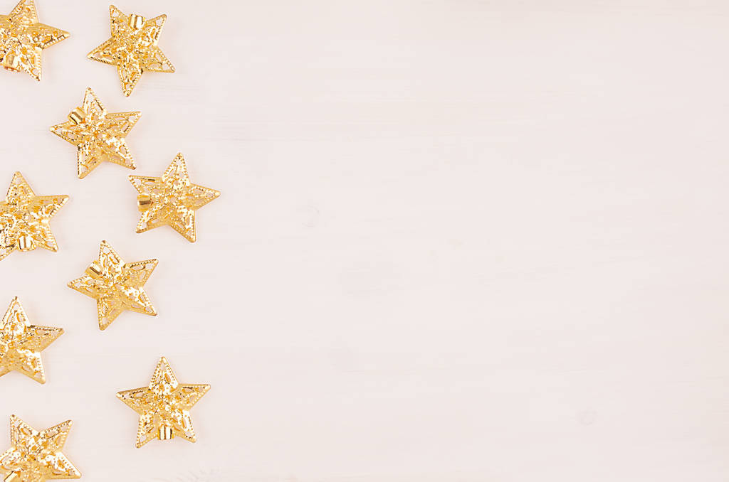 Decoraciones festivas, estrellas doradas sobre fondo blanco de madera
. - Foto, imagen