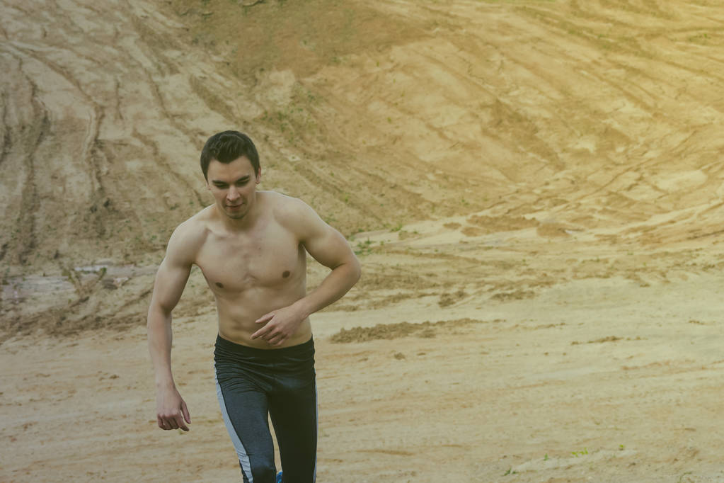 Молодой человек бежит по пустыне
 - Фото, изображение