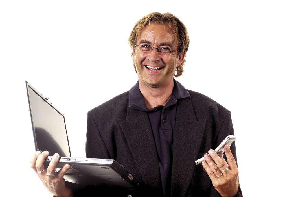 Strahlender Mann mit Laptop und Handy, Handy in der Hand - Foto, Bild