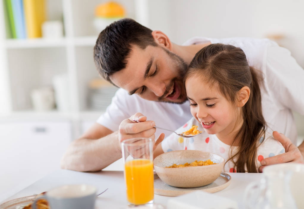 ευτυχισμένη οικογένεια τρώει νιφάδες για πρωινό στο σπίτι - Φωτογραφία, εικόνα