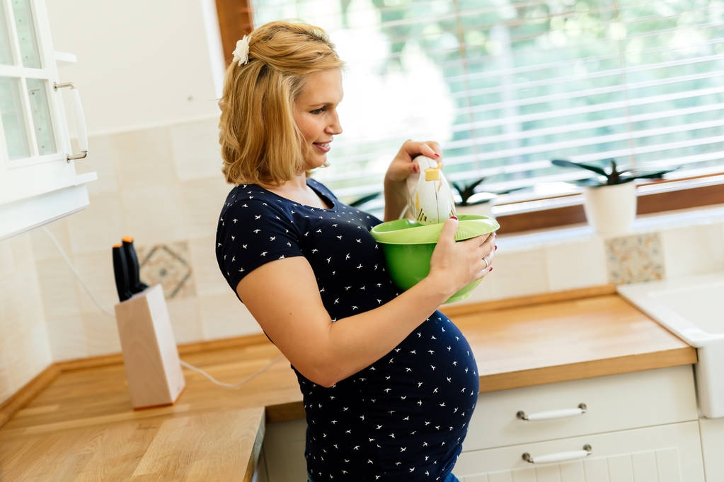 Schwangere arbeitet in Küche - Foto, Bild