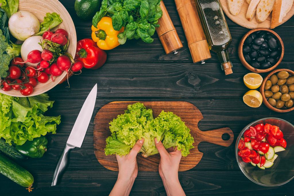mains avec feuilles de salade et légumes
 - Photo, image