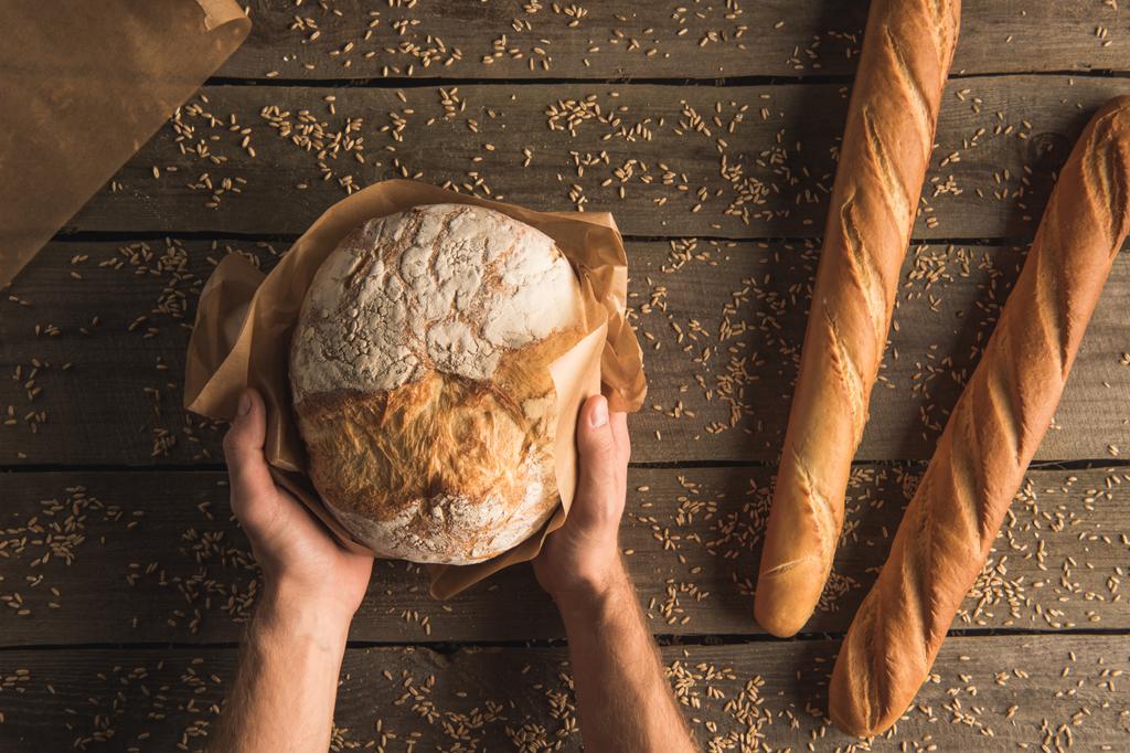 pão nas mãos e baguetes
 - Foto, Imagem