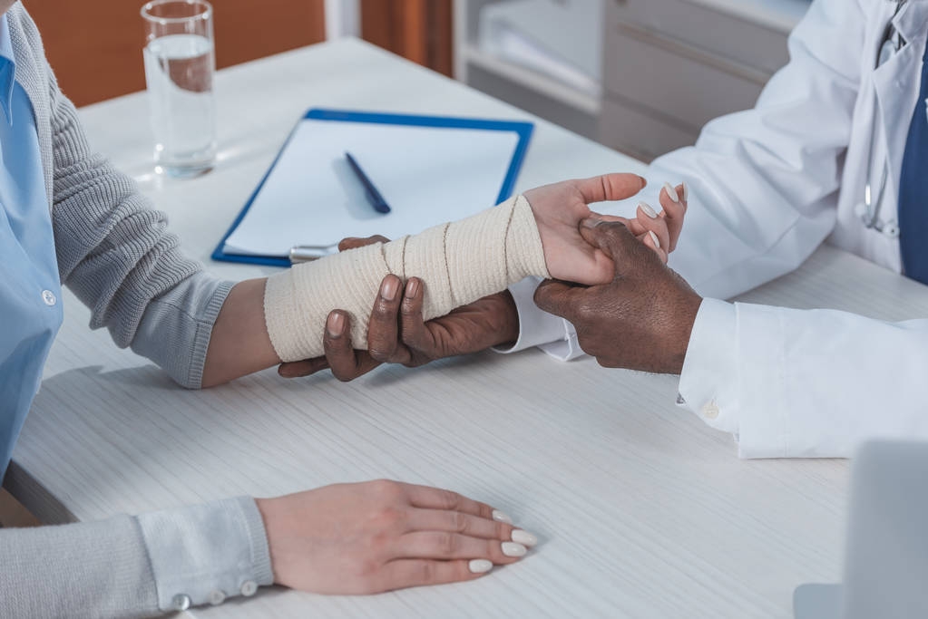 Arzt untersucht verletzte Hand - Foto, Bild