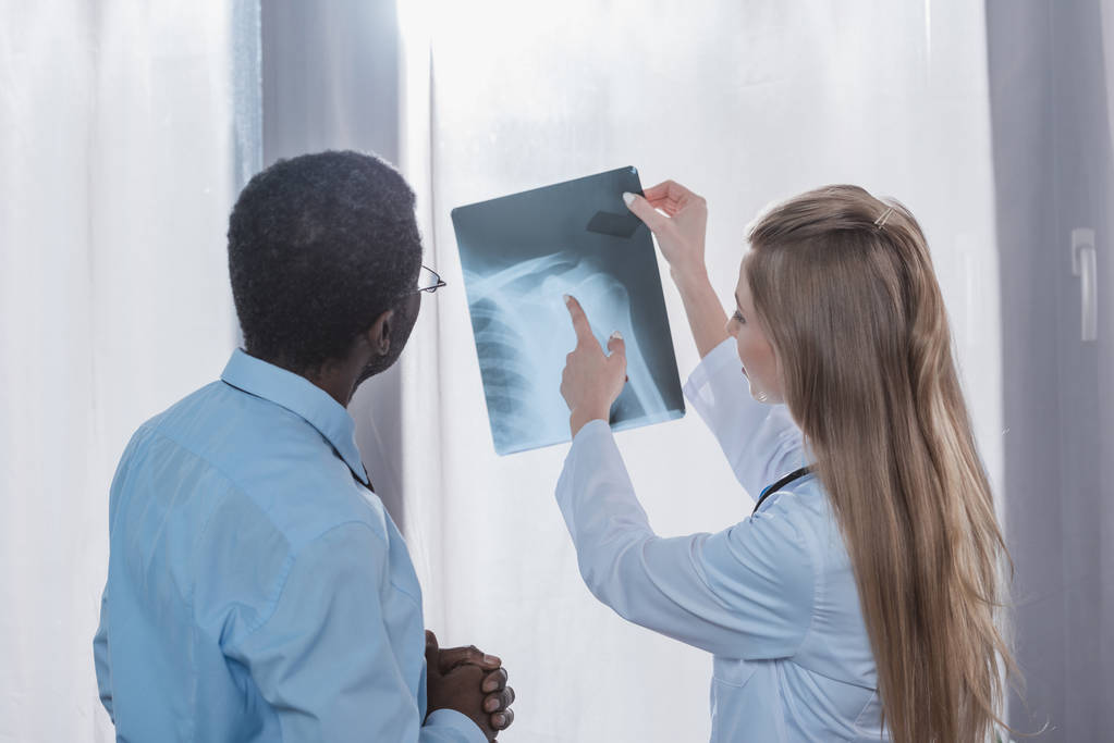 Лікар, який показує рентгенівський знімок пацієнту
  - Фото, зображення