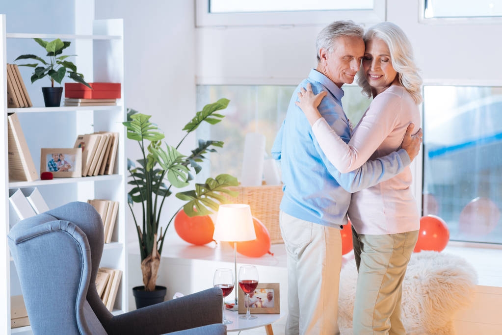alegre jubilado pareja bailando durante romántico fecha en casa
 - Foto, imagen