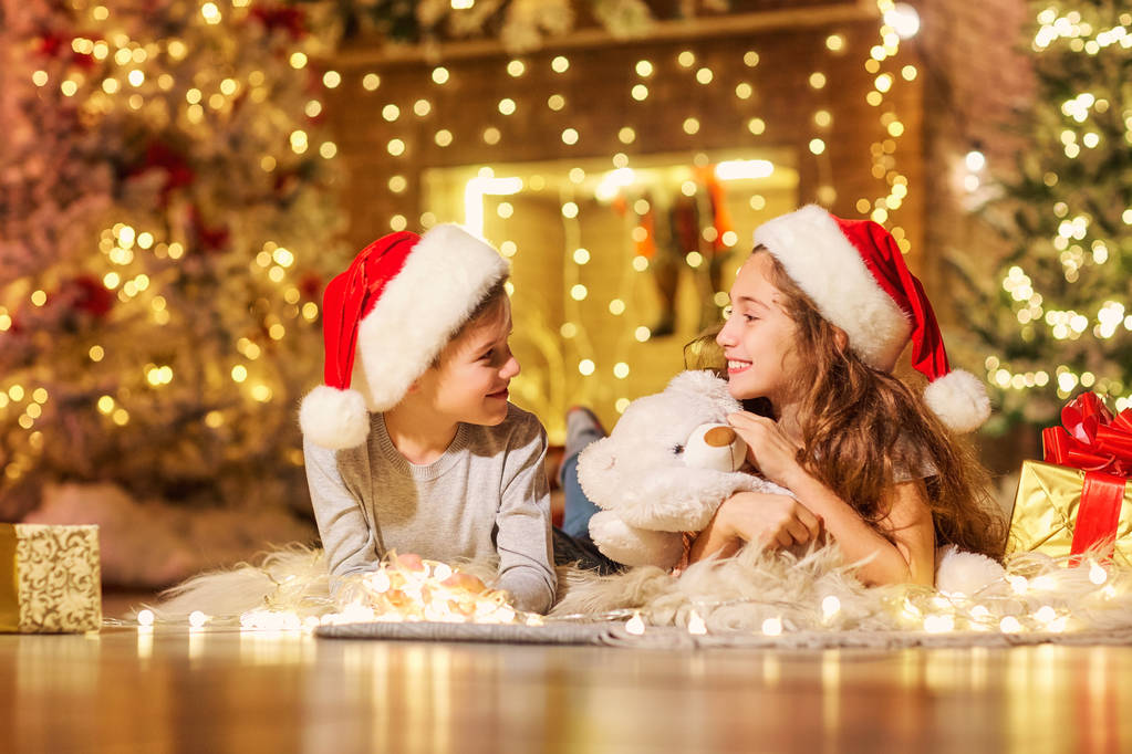 Deux enfants avec des cadeaux dans une chambre à Noël
. - Photo, image