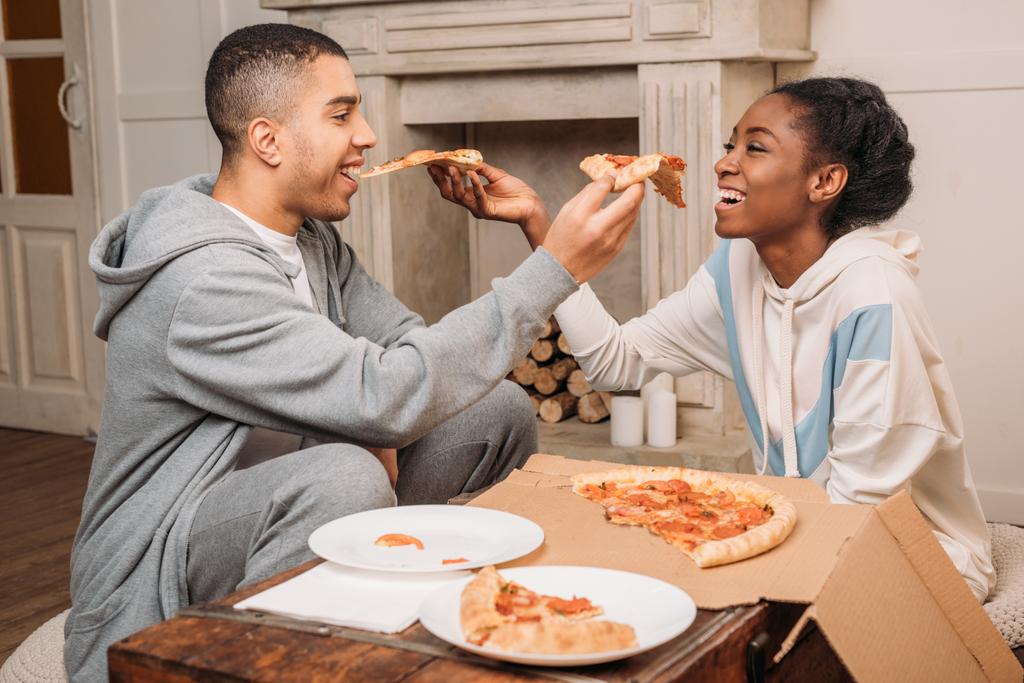 пара делится ломтиками пиццы
  - Фото, изображение