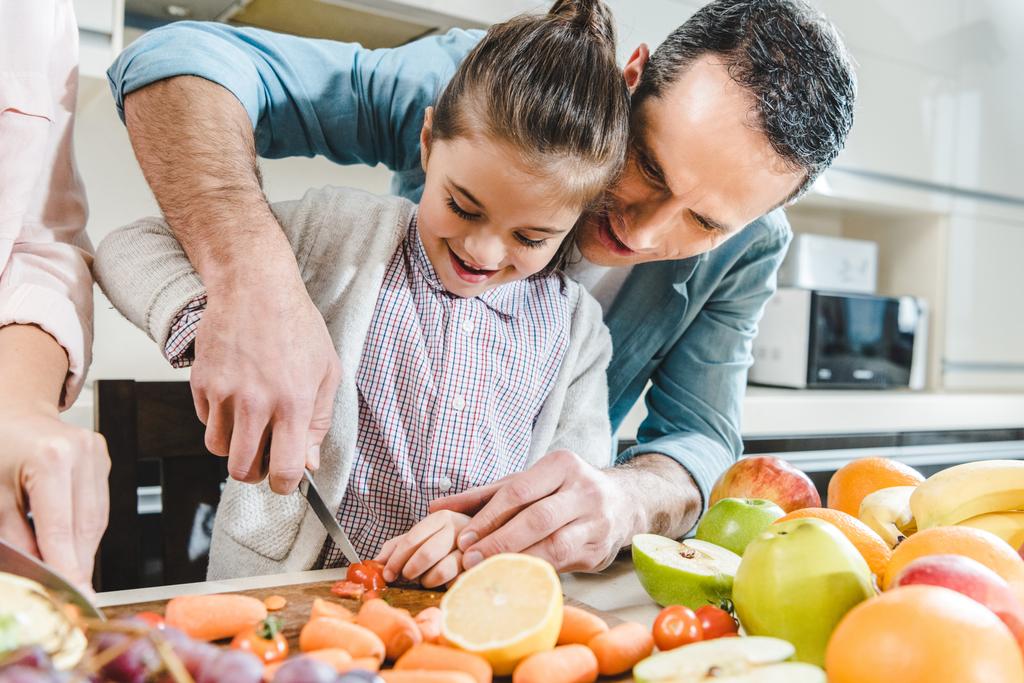 батько з дочкою нарізає овочі та фрукти
 - Фото, зображення