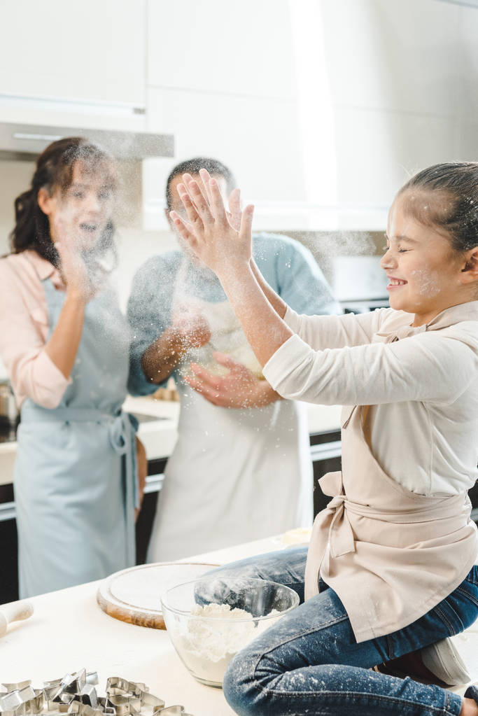 glückliche Familie, kleines Kind klatscht in der Küche mit Mehl in die Hände - Foto, Bild