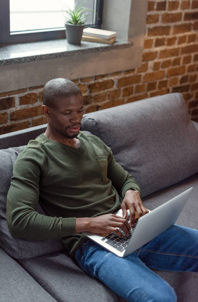 Afro-Amerikaanse man typen op laptop - Foto, afbeelding
