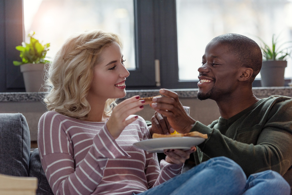 portrait de heureux jeune couple multiculturel prenant le petit déjeuner ensemble à la maison
 - Photo, image