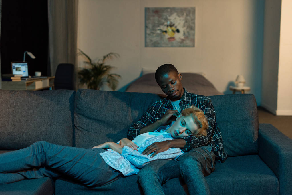 afro-américain homme regardant petite amie dormir sur ses genoux à la maison
 - Photo, image