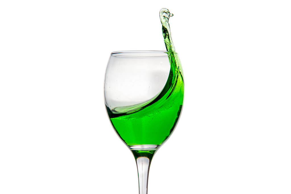 Verre à vin avec éclaboussures gouttes de cocktail d'alcool vert
 - Photo, image