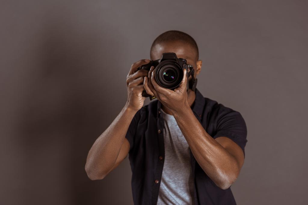 vue obscurcie du photographe afro-américain prenant des photos sur appareil photo
 - Photo, image