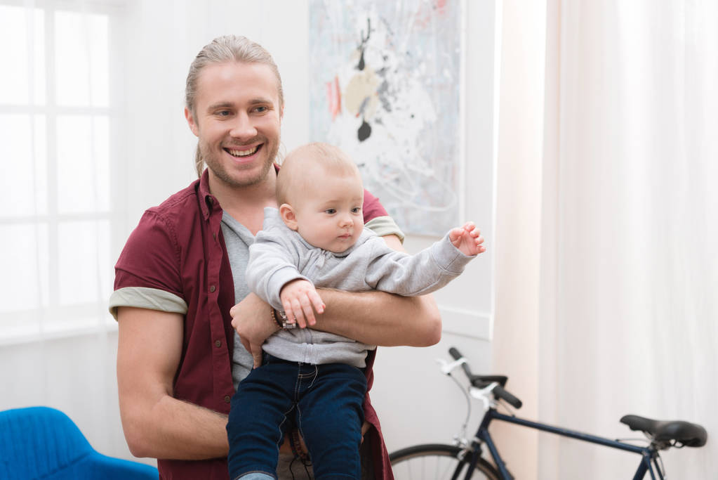 mutlu baba erkek bebek üzerinde evde elele - Fotoğraf, Görsel