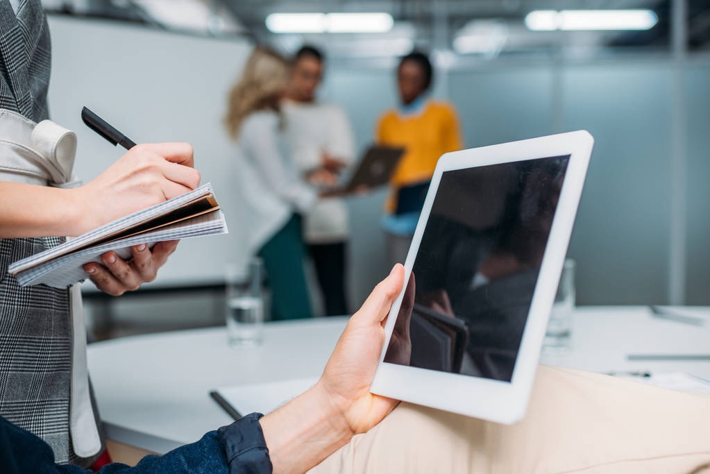 uomo d'affari in possesso di tablet con schermo bianco in ufficio moderno mentre collega prendere appunti
 - Foto, immagini