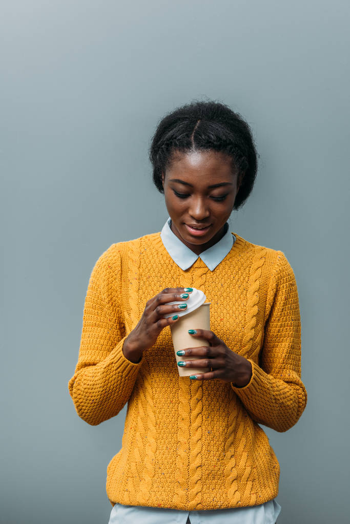 使い捨て可能なコーヒー カップを持つ若いアフリカ系アメリカ人女性 - 写真・画像