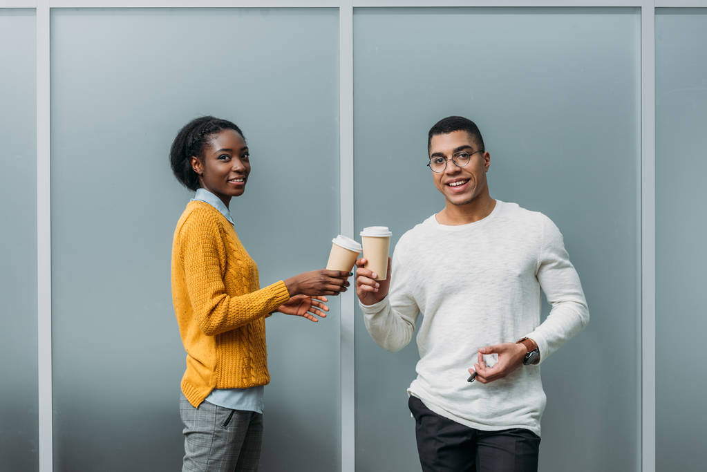 junge afrikanisch-amerikanische Geschäftspartner klingeln an Einwegbechern mit Kaffee - Foto, Bild