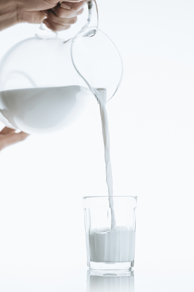 kişi dökülen süt cam içine - Fotoğraf, Görsel