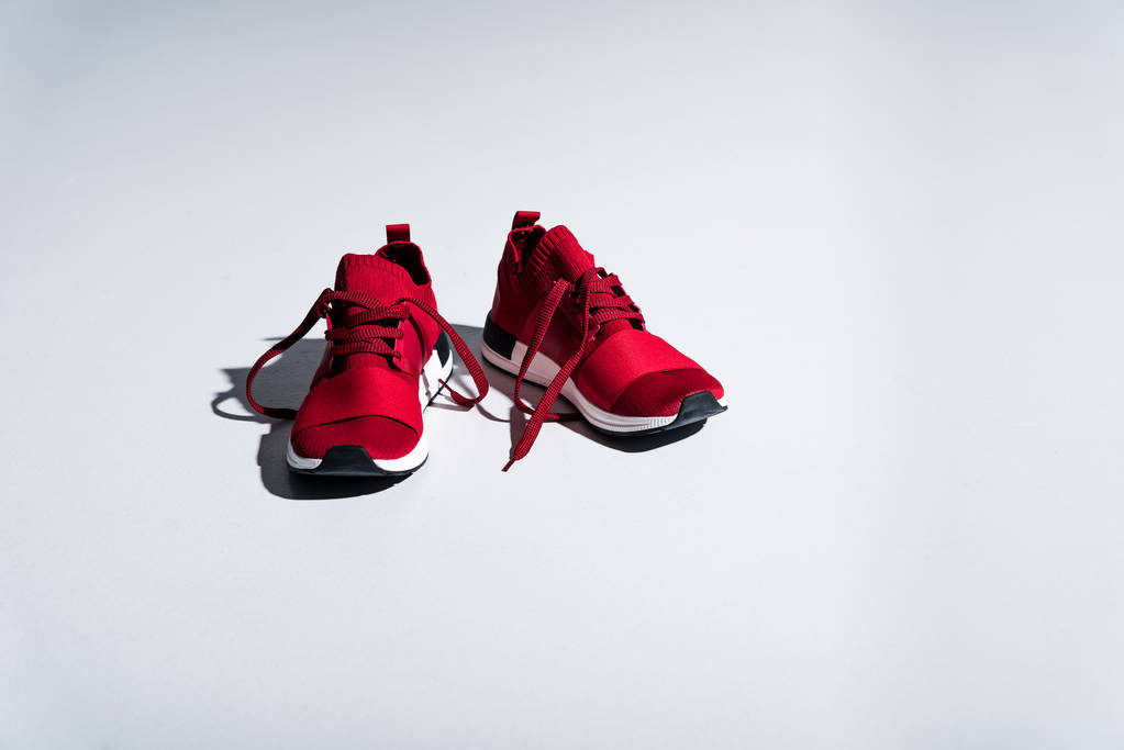 крупный план красных кроссовок, изолированных на сером
 - Фото, изображение