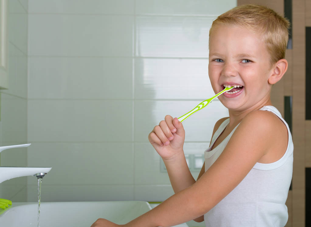 Niño cepillarse los dientes en el baño.El comienzo de un nuevo día
 - Foto, imagen